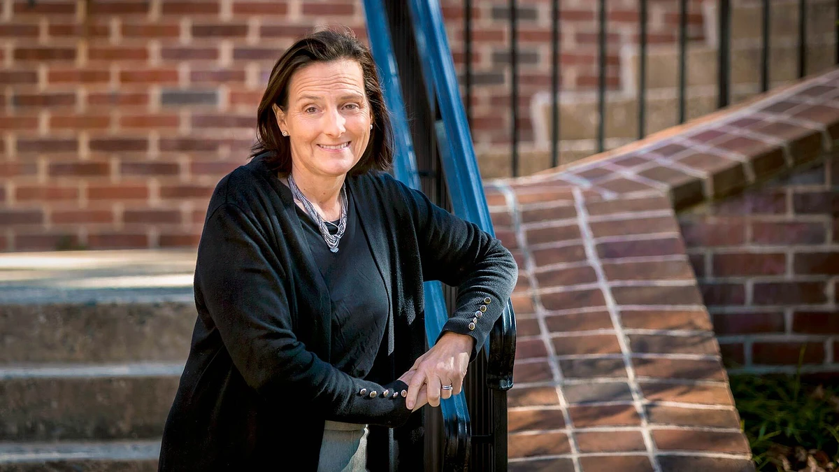 Emily Lucio, UMD's new ADA/504 coordinator, leaning against rails on stairs